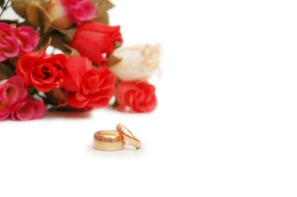 两个结婚戒指和鲜花背景 — 图库照片