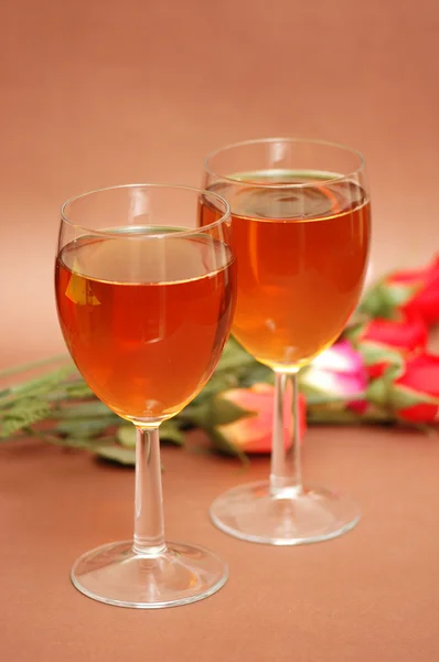 Dois copos de vinho e flores no fundo — Fotografia de Stock