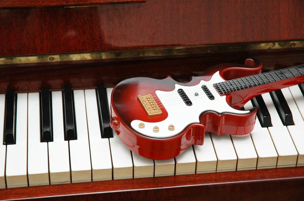 Guitar on the piano keys — Stock Photo, Image