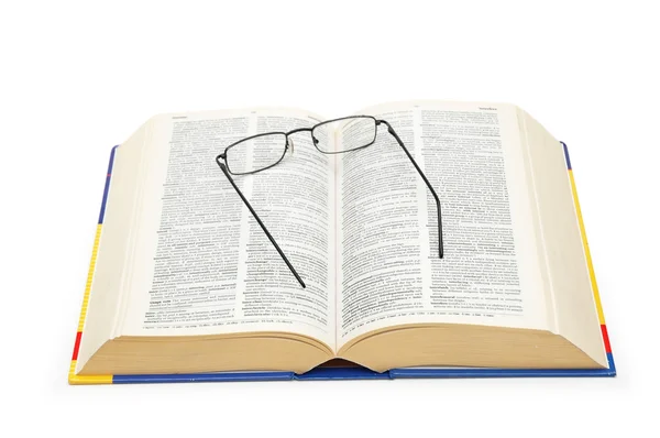 Γυαλιά πάνω από το ανοιχτό λεξικό που απομονώνονται σε λευκό — Φωτογραφία Αρχείου