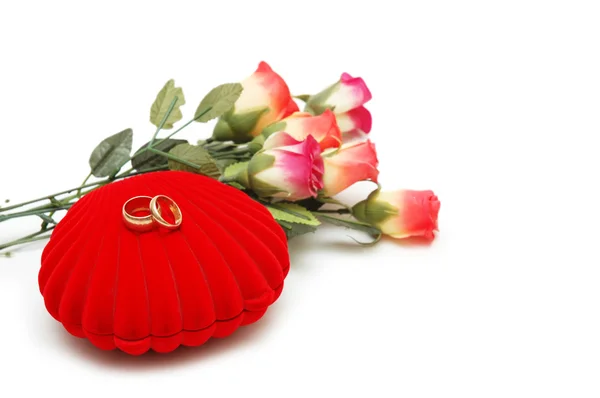 Flores, caixa em forma de coração e anéis de casamento isolados em branco — Fotografia de Stock