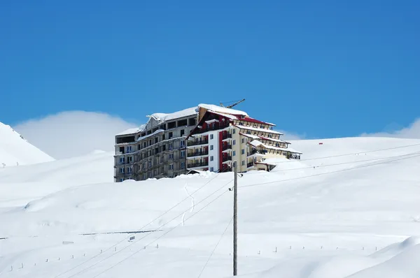 雪で覆われた山の頂上で大きなホテル — ストック写真
