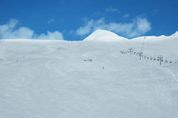 Berg bedekt met sneeuw en skiërs — Stockfoto