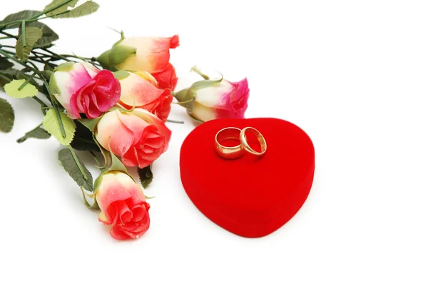 Flores, caixa em forma de coração e anéis de casamento isolados em branco — Fotografia de Stock