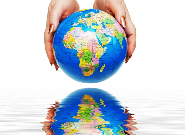 Twee handen met een globe geïsoleerd op wit met weerspiegeling in het water — Stockfoto