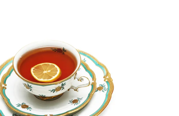 Чай с лимоном и блюдцами изолированы на белом — стоковое фото