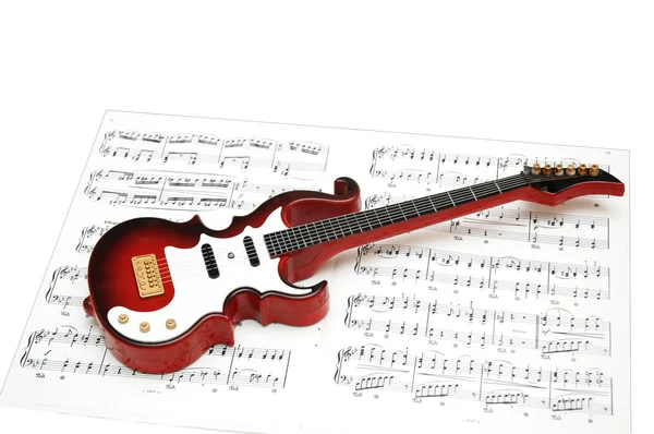 Рок-гітара над аркушем друкованої музики — стокове фото