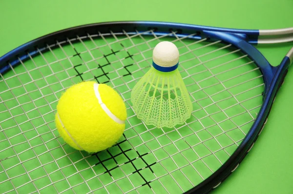 Tenisový míček, kuželka a raketa na zeleném pozadí — Stock fotografie