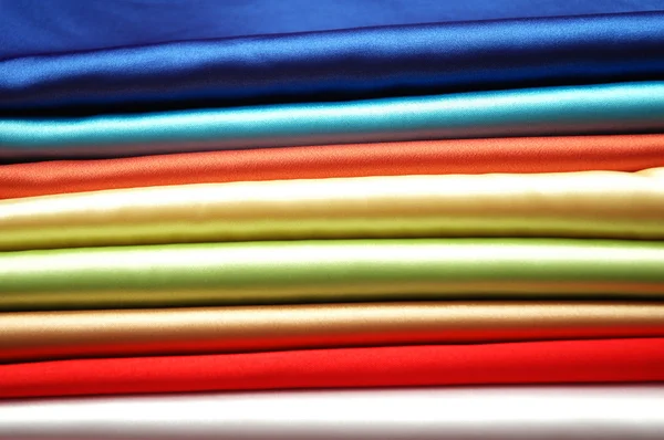 Tumpukan kain satin dari berbagai warna — Stok Foto