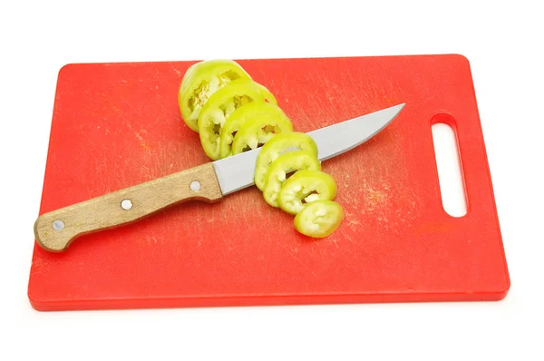 Nůž a plátky zelené papriky na prkénku — Stock fotografie