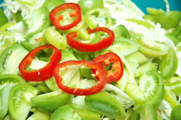 Green tomatoes and red sliced peppers — Stock Photo, Image