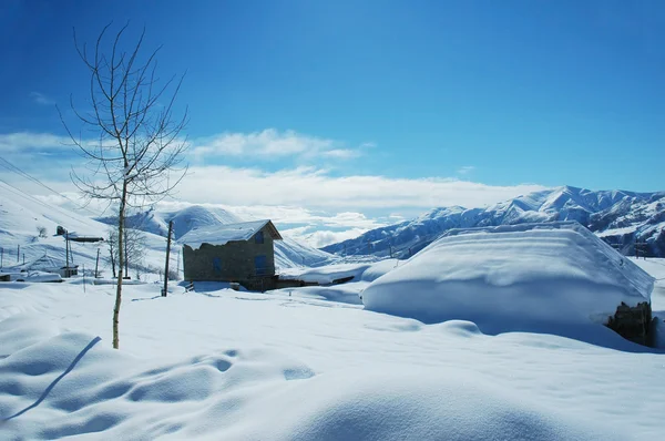 Huizen en de bergen onder de sneeuw in de winter - Georgië, Marokko — Stockfoto