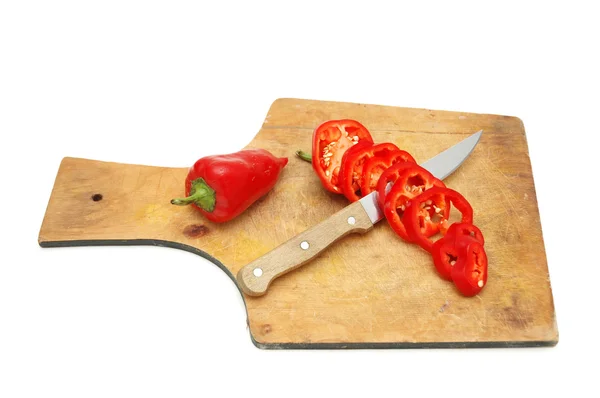 Skivad röd paprika på skärbräda isolerad på vit — Stockfoto