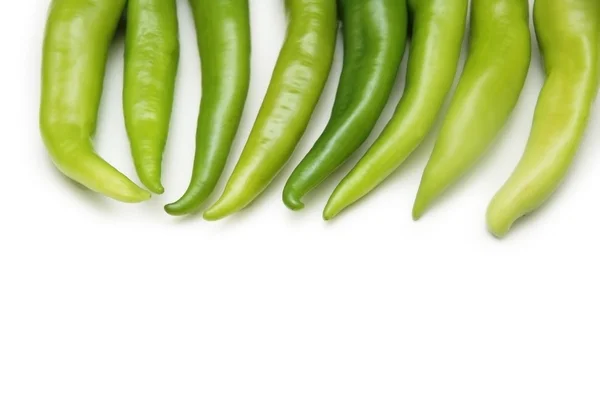 Zelené papriky v řadě izolovaných na bílém — Stock fotografie