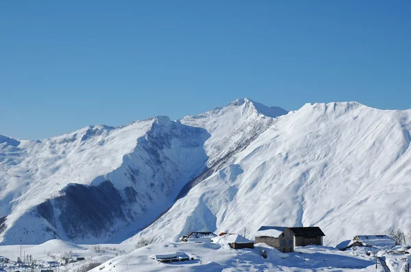 Montañas y casas bajo la nieve en invierno — Foto de Stock