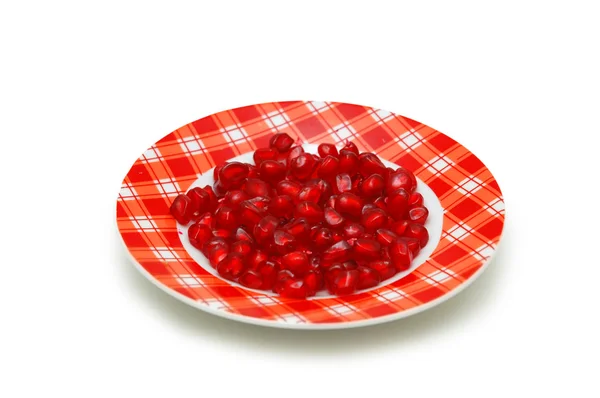 Тарелка, полная семян красного граната, изолированных на белом — стоковое фото