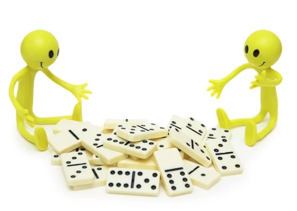 Două zâmbete jucându-se cu domino izolate pe alb — Fotografie, imagine de stoc