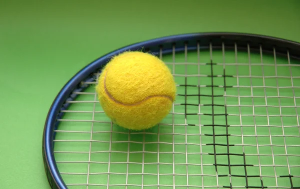 Tennisracket och boll på grön bakgrund — Stockfoto