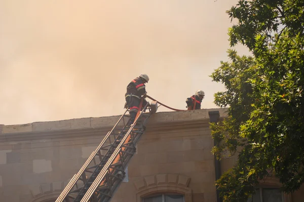 Strażacy na dachu podczas pożaru — Zdjęcie stockowe