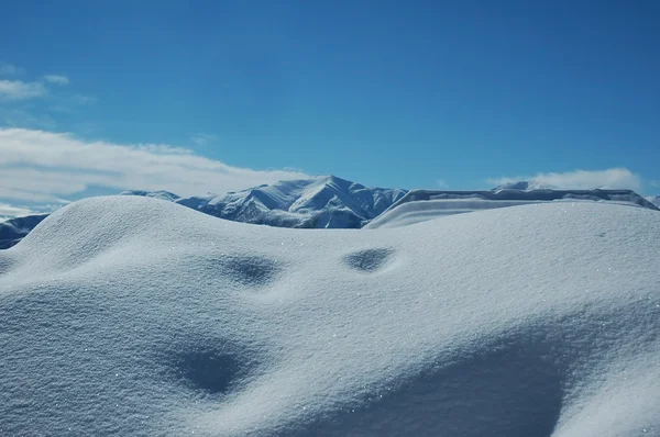 Rüzgârla oluşan kar yığını ve açık mavi gökyüzü — Stok fotoğraf
