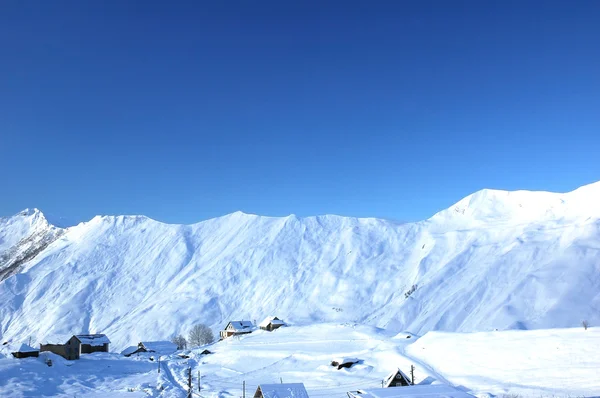 Winterlandschaft mit Bergen und Häusern — Stockfoto
