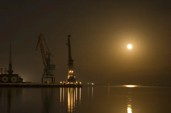 Kranar i baku hamn på natten med månen — Stockfoto