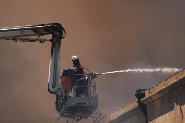 Firefighter on a boom during fire — Stock Photo, Image