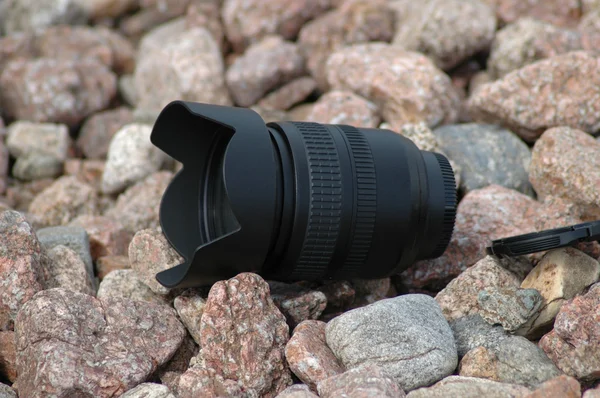 Çakıl taşları üzerinde kamera objektifi — Stok fotoğraf