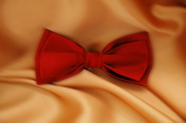 Arcul roșu cravată pe fundal portocaliu — Fotografie, imagine de stoc