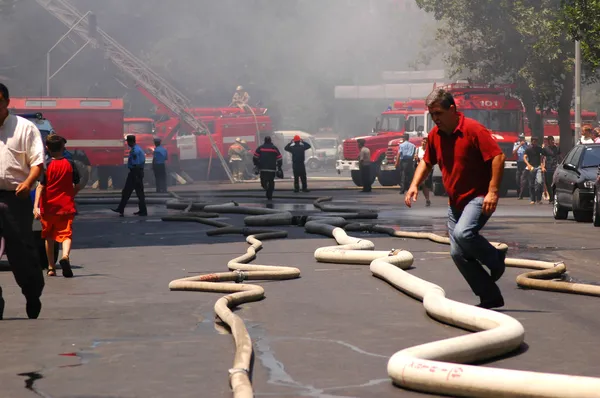 Fire hoses stretching across the street during fire — Stock Photo, Image
