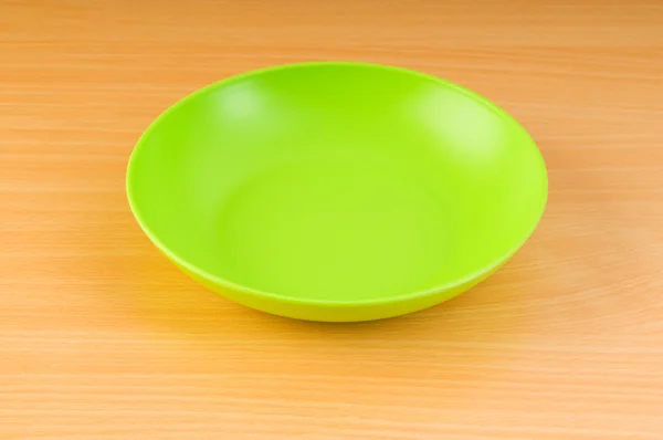 Prázdný talíř na dřevěný stůl — Stock fotografie