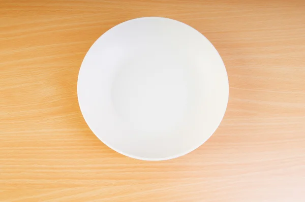 Leerer Teller auf dem Holztisch — Stockfoto