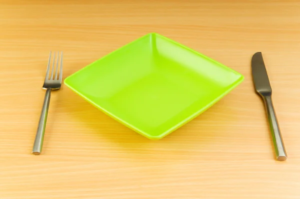 Тарелка с посудой на деревянном столе — стоковое фото