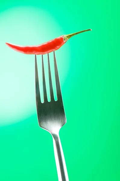 Hot pepper on the fork against colour background — Stock Photo, Image