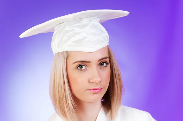 Feliz graduado contra fondo colorido — Foto de Stock