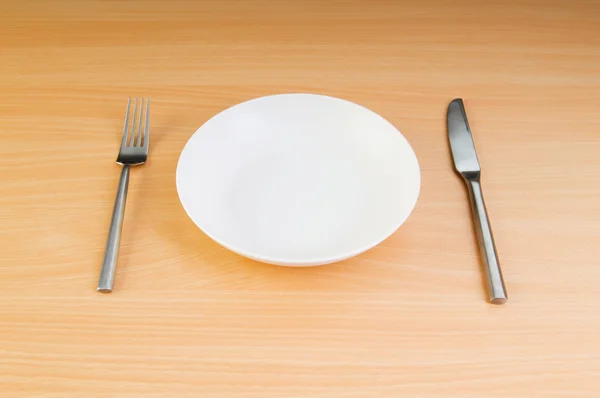 Тарелка с посудой на деревянном столе — стоковое фото