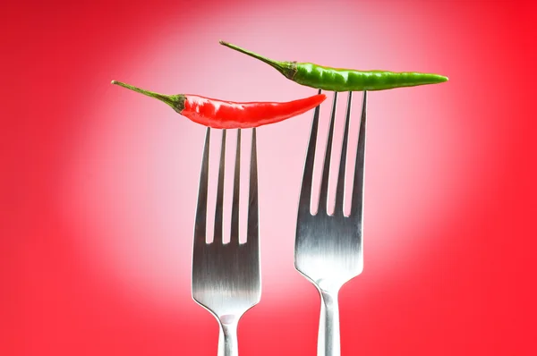 Peppar på gaffeln mot färg bakgrund — Stockfoto