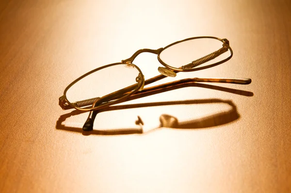 Reading glasses on the wooden table — Stock Photo, Image