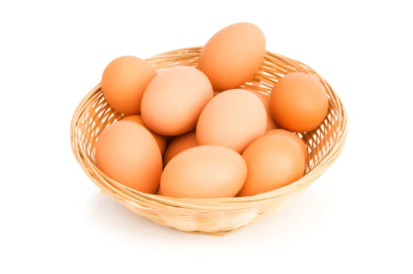 Hnědá vejce v košíku na bílém — Stock fotografie
