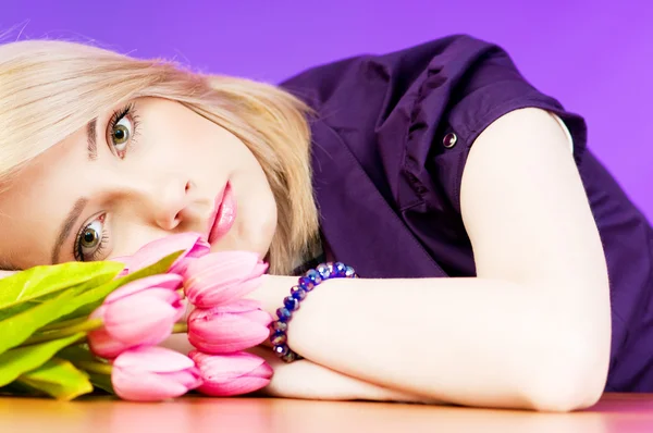 Jong meisje met tulpen tegen kleurrijke achtergrond — Stockfoto