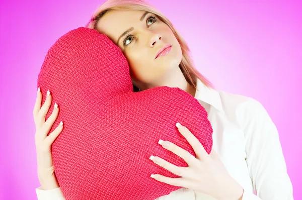 Romantic concept with girl and heart-shaped pillow — Stock Photo, Image