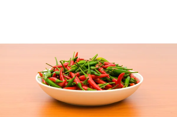 Paprika im Teller auf Holztisch — Stockfoto