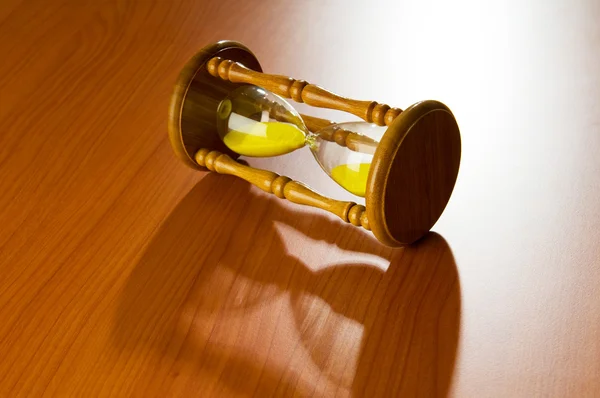 stock image Time concept with hourglass on wooden background