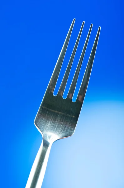 Silver fork against gradient color background Stock Photo