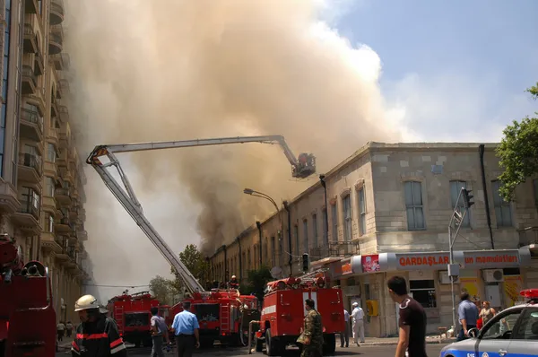 Πυροσβέστες σε έναν βραχίονα κατά τη διάρκεια πυρκαγιάς σε το citycentre — Φωτογραφία Αρχείου