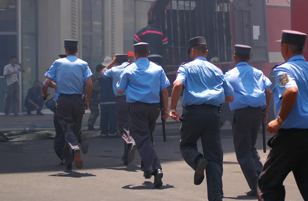 Policemen with batons running away — Stock Photo, Image