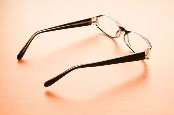 Reading glasses on the wooden table — Stock Photo, Image