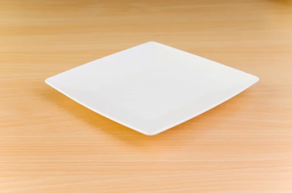 Pusty talerz na stole drewniane — Zdjęcie stockowe