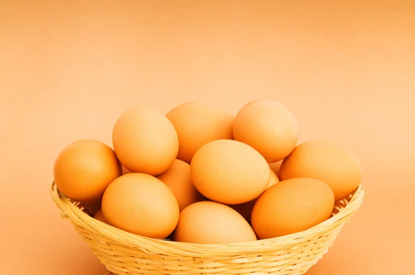 Korb mit Eiern auf dem bunten Hintergrund — Stockfoto