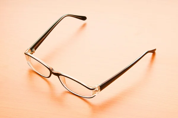 Reading glasses on the wooden table — Stock Photo, Image